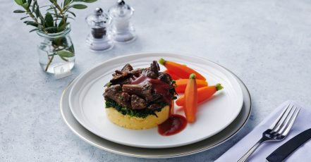 Lecker durch den Veganuary. Dieses Kunstwerk aus cremigem Polentakuchen mit Thymian-Pilz-Ragout und sautiertem Spinat gibt es für die First Class Gäste von Emirates. Das vegane Speisenangebot der weltweit größten Airline ist eine gute Anregung für jeden Event-Caterer. (Bildrechte: Emirates)