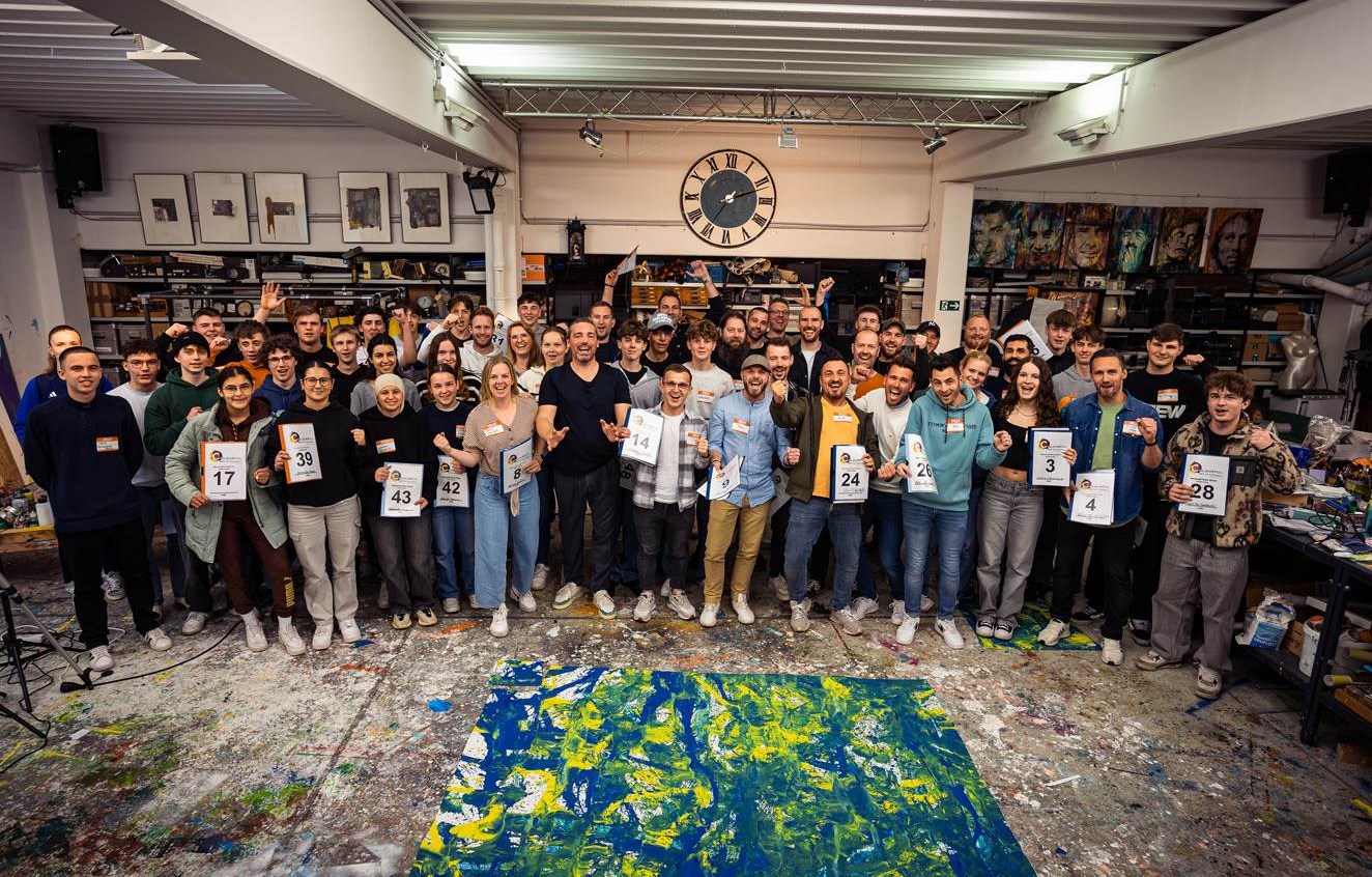 Vorbereitungsevent zu "The Colourful Art of Football". Christian Nienhaus (Bild-Mitte, schwarzes T-Shirt) mit allen Freiwilligen, die sich am 5.5.2024 am "größten Bild der Welt" beteiligen werden. (Bildrechte: Christian Nienhaus / TAS Emotional Marketing)