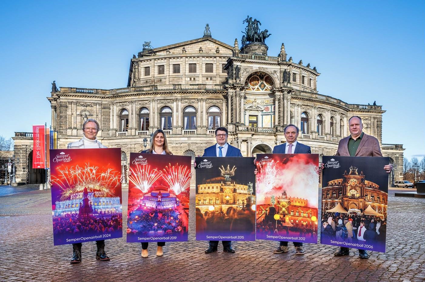 Foto von der Pressekonferenz zum SemperOpernball 2025; (v.li.) Wolfgang Lippert, Stefanie Schlick, Joachim Hoof, Gerhard Müller und Dirk Hilbert halten Motive von vergangenen SemperOpenairBällen in den Händen. (Copyright: Semper Opernball e.V./ Riverside Entertainment GmbH / Eric Münch) 